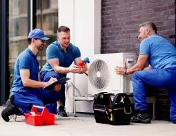 Technicians checking a compact outdoor air conditioning unit