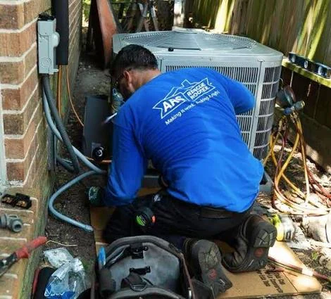 Technician repairing an outdoor air conditioner beside a home